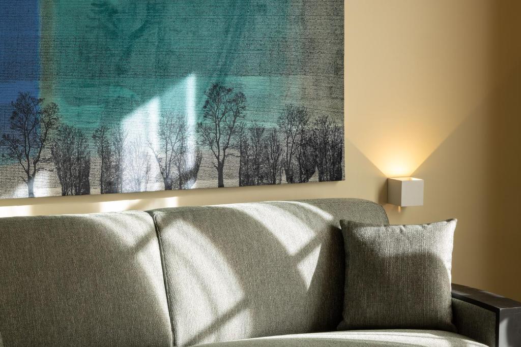 a couch in a living room with a painting on the wall at Palais Ségurane Boutique Hôtel in Nice