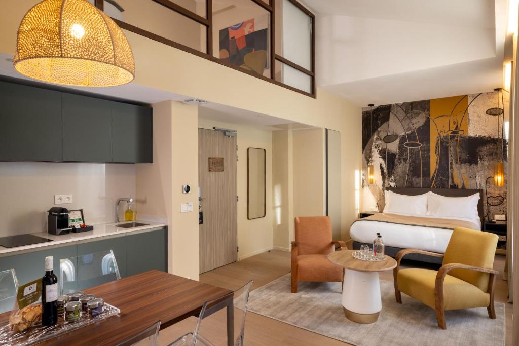 a hotel room with a bed and a dining room at Palais Ségurane Boutique Hôtel in Nice