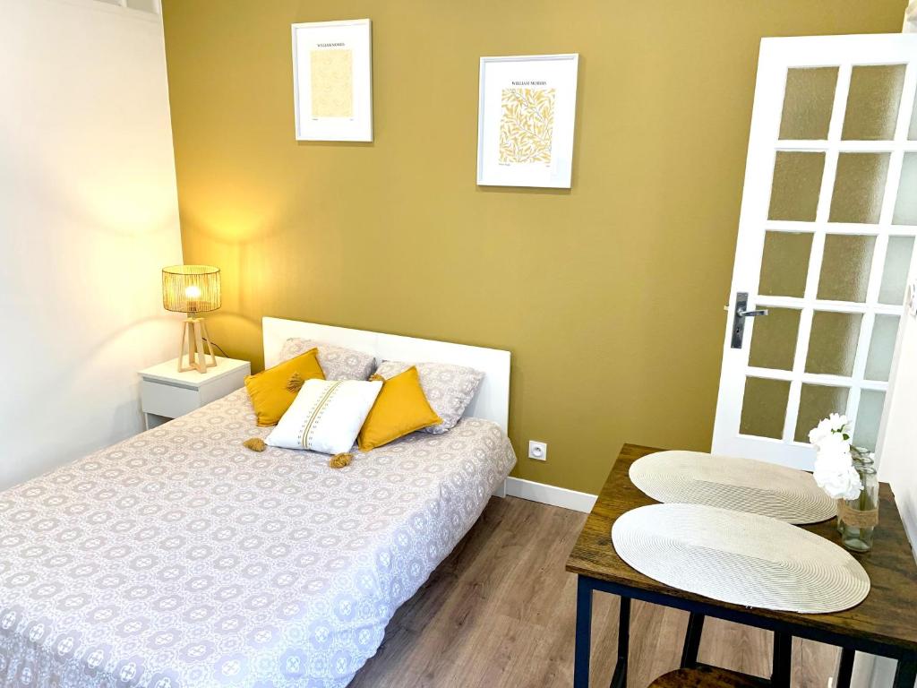 - une petite chambre avec un lit et une table dans l'établissement Appartement Cosy entre la gare et l'hypercentre - tout confort - résidence calme, à Lorient