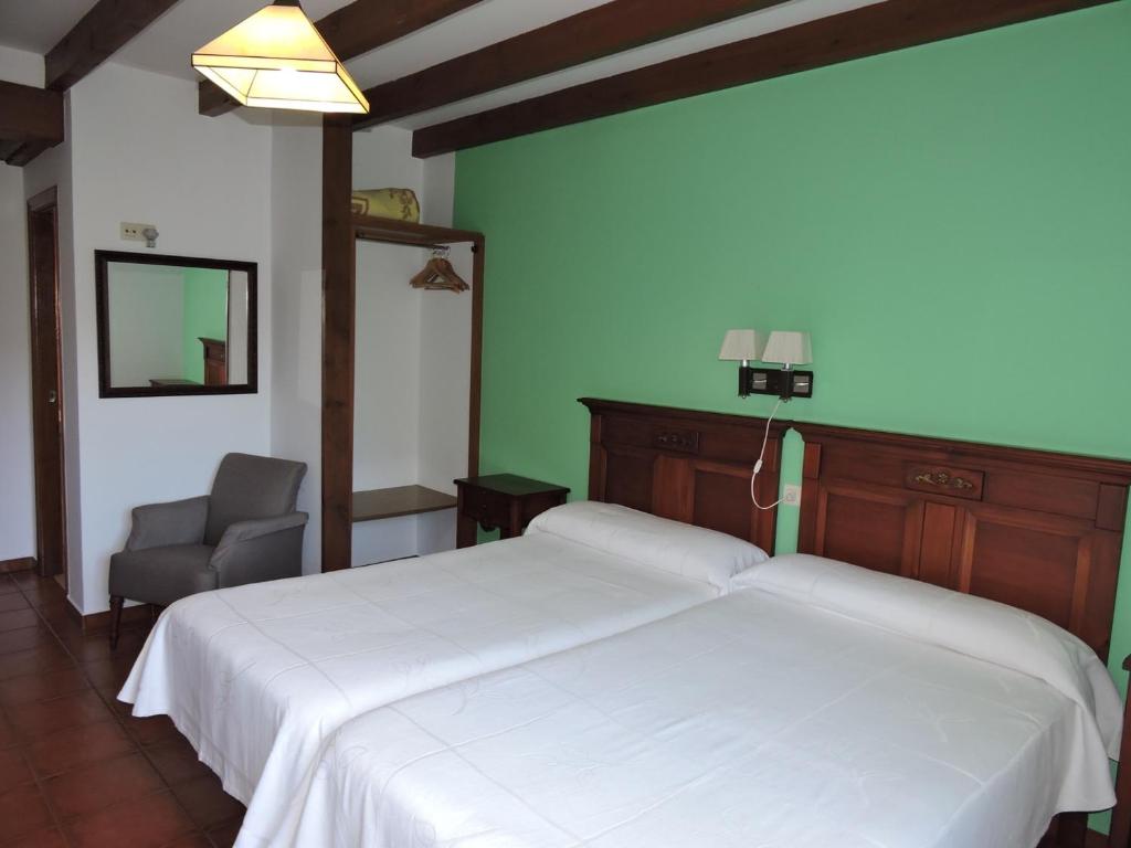 a bedroom with a white bed and a chair at Casa Pancho Porrúa in Porrúa