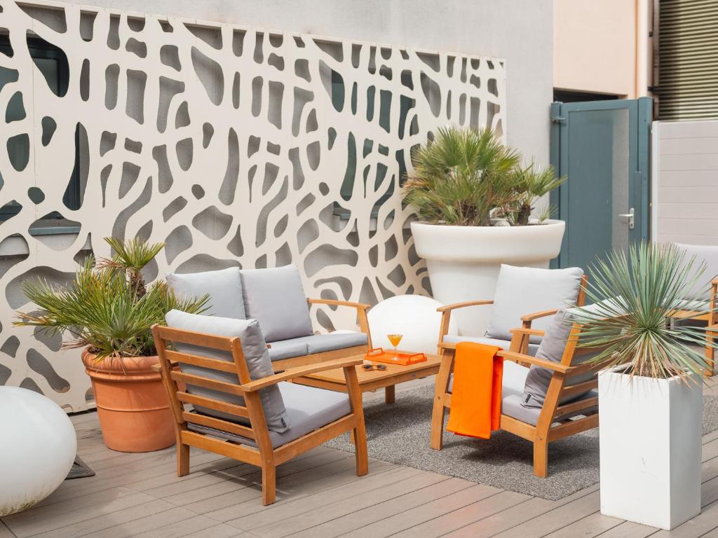 um pátio com duas cadeiras, uma mesa e plantas em Holiday Inn Toulouse Airport by IHG em Blagnac
