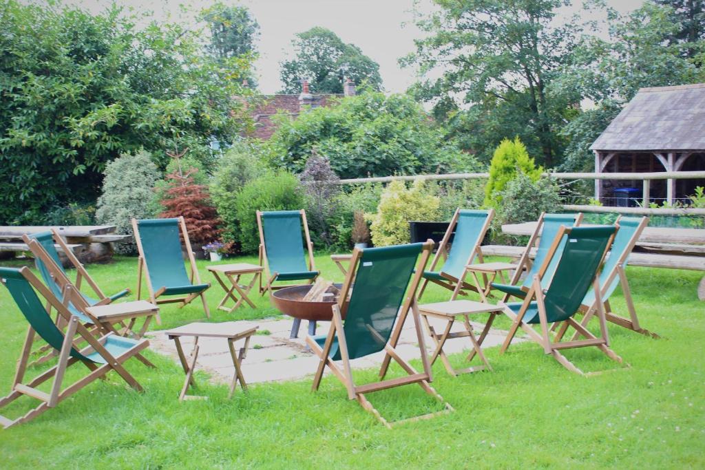 un gruppo di sedie da giardino sedute sull'erba di The Kings Head a Whiteparish