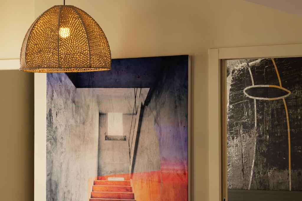 a chandelier hangs over a painting next to a door at Palais Ségurane Boutique Hôtel in Nice
