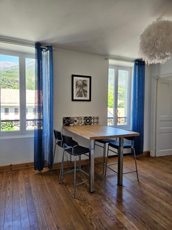 una sala da pranzo con tavolo e 2 sedie di Le cocon de la Pare- Superbe T3 plein centre a Barcelonnette