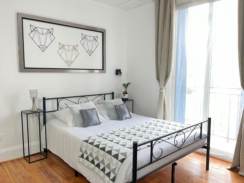une chambre avec un lit noir et blanc et une fenêtre dans l'établissement Résidence Harmony, à Vichy