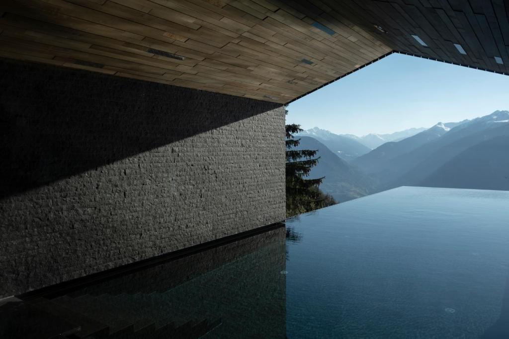 a swimming pool with a view of the mountains at Miramonti Boutique Hotel in Avelengo