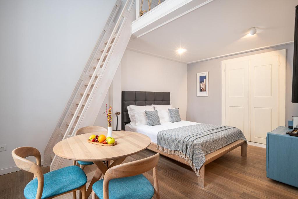 a bedroom with a bed and a table and chairs at Clouds Boutique Guesthouse in Dubrovnik