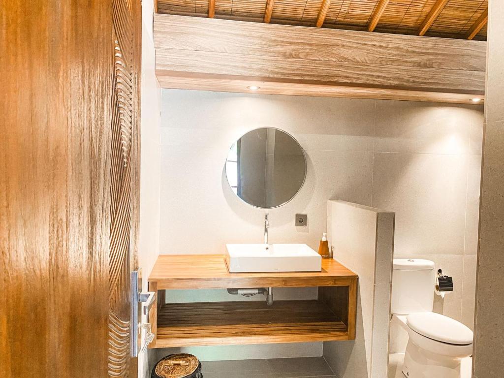 een badkamer met een wastafel en een toilet bij Karunia House Ubud in Ubud