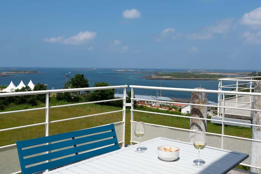 - un balcon avec une table et deux verres de vin dans l'établissement Appart avec vue mer incroyable sur l'Aber Wrac'h, à Landéda