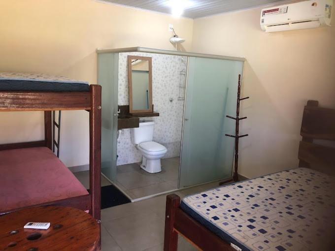 ein Zimmer mit einem Badezimmer mit Toilette und Spiegel in der Unterkunft Chácara Por do Sol Beira Lago in Palmas