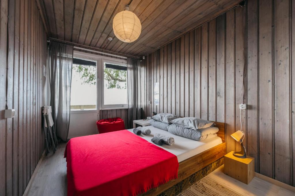 a bedroom with a large bed with a red blanket at El Nido in Nida