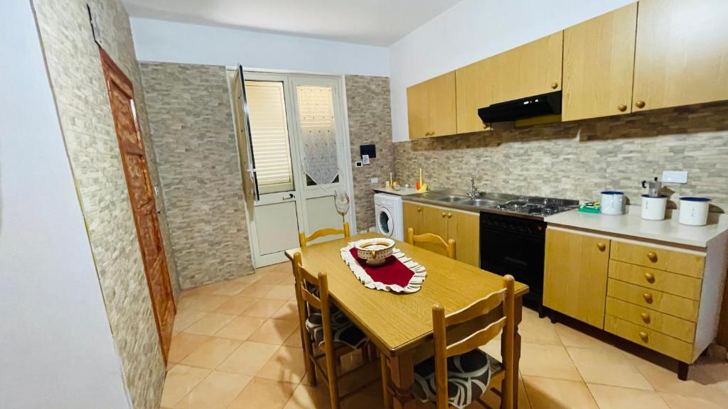 a kitchen with a wooden table and a table and a tableablish at Casa vacanza contrada canalotto 65 in Realmonte