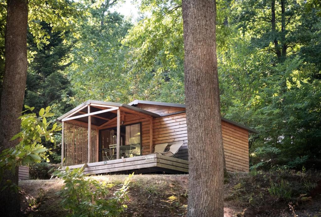 une petite cabane en bois entourée d'arbres dans l'établissement Huttopia de Wattwiller, à Wattwiller