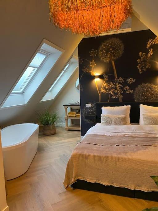 a bedroom with a large bed and a bath tub at Ricks Room Barneveld in Barneveld