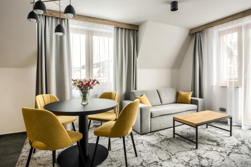 sala de estar con sofá, mesa y sillas en Szlakami 5 Dolin - apartamenty obok Doliny Strążyskiej - Giewont en Zakopane