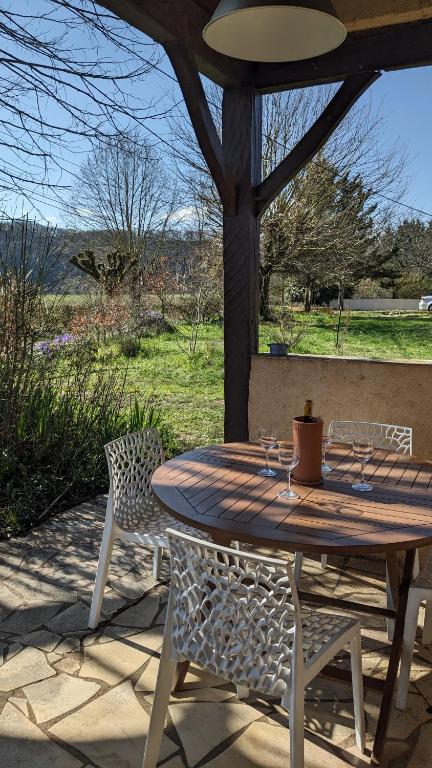 une table et des chaises en bois sur une terrasse dans l'établissement Maison au calme en Dordogne, à Trémolat