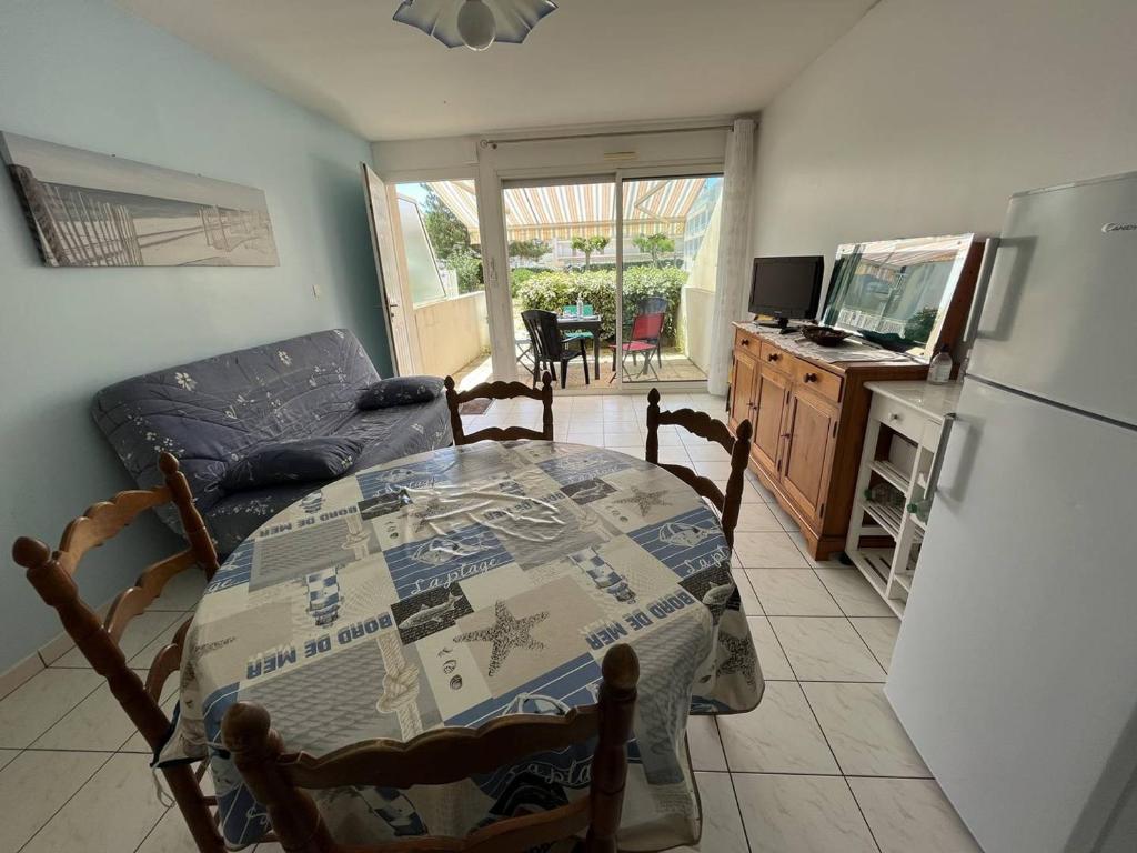 une cuisine avec une table et un réfrigérateur dans l'établissement Appartement Calme avec Terrasse, Piscine et Parking à 250m de la Plage - FR-1-324A-16, à Saint-Hilaire-de-Riez