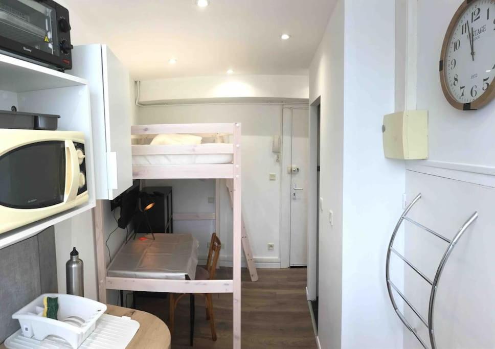 Cette petite chambre comprend des lits superposés et une horloge. dans l'établissement Studio GUITAR, à Chambéry