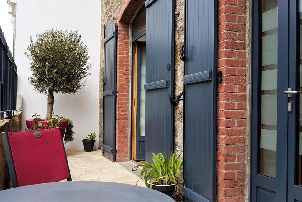 d'une terrasse avec une porte bleue et une table. dans l'établissement Le Cap Horn, à Dinard