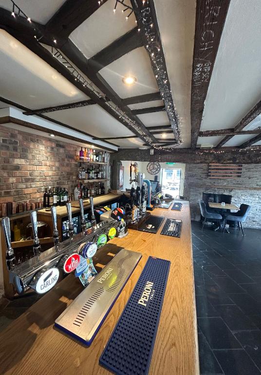 een bar met een lang houten aanrecht in een kamer bij The Swan Hotel in Upton upon Severn