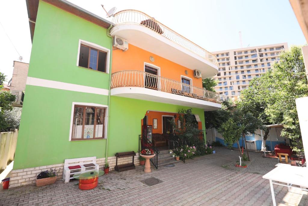 ein grünes und orangefarbenes Haus mit einem Balkon in der Unterkunft Hostel Osho in Tirana