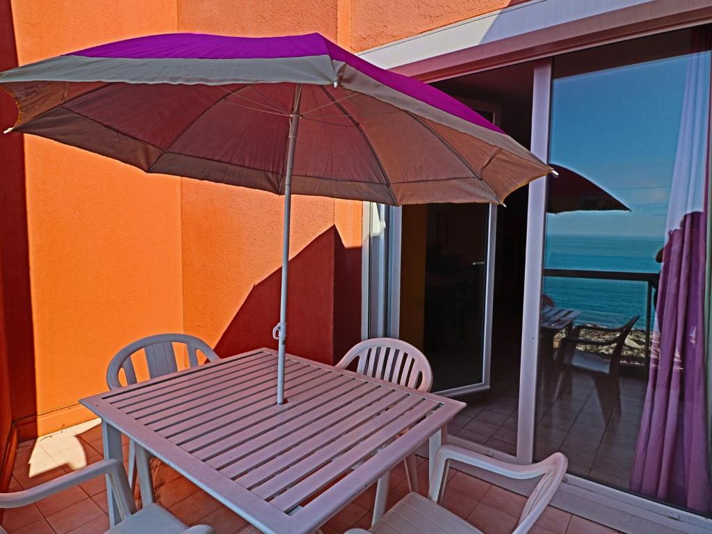 - une table de pique-nique avec un parasol sur le balcon dans l'établissement Studio cabine 4 pers, accès plage, piscine, parking - FR-1-472A-148, à Sète