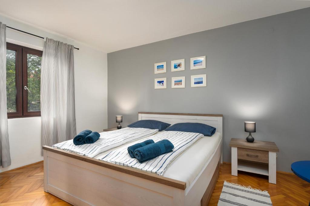a bedroom with a bed with two blue pillows on it at Blue Apartment in Vrsar