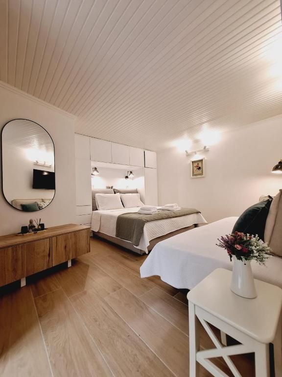 a large bedroom with two beds and a mirror at Casa Myrilla in Corfu