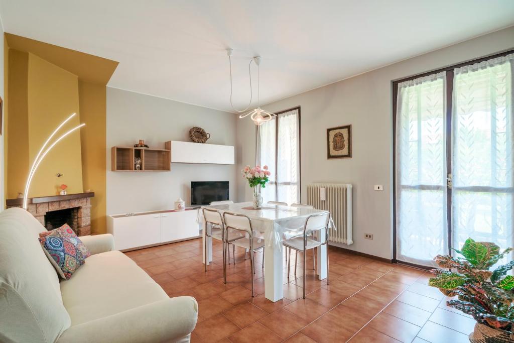 ein Wohnzimmer mit einem weißen Tisch und Stühlen in der Unterkunft Casa Maria - trilocale con patio, garage e WiFi in San Martino della Battaglia