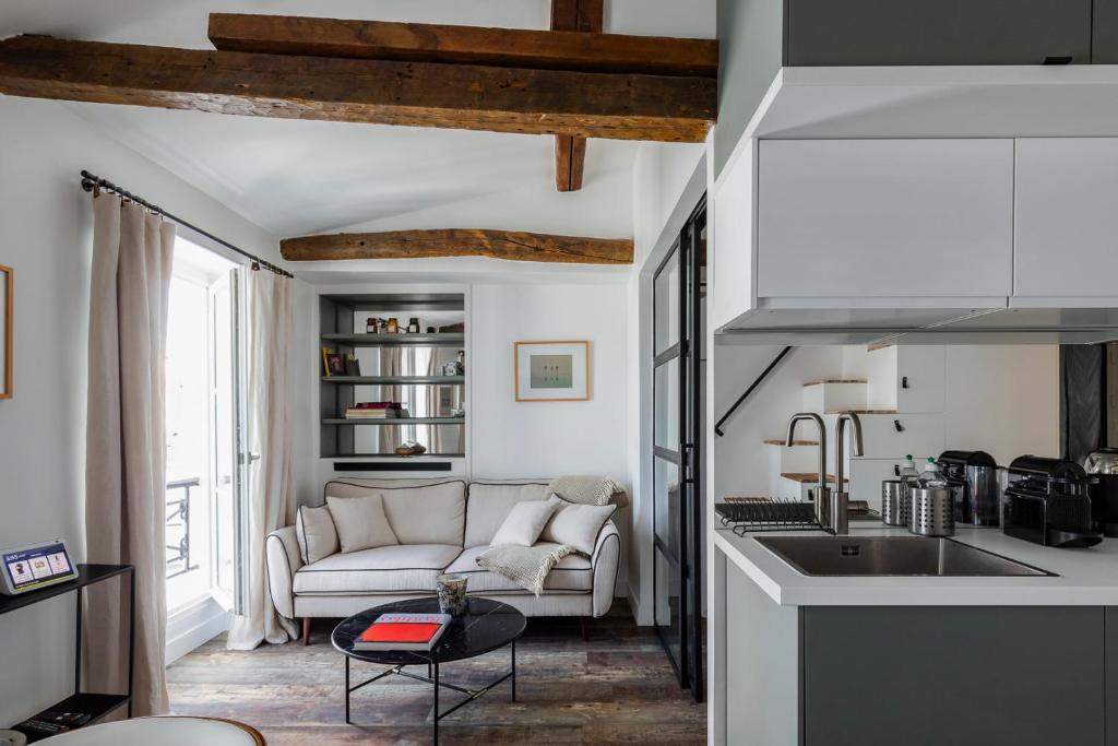 une cuisine et un salon avec un canapé et une table dans l'établissement Charming newly renovated apartment in the heart of Paris St Germain des Pres, à Paris