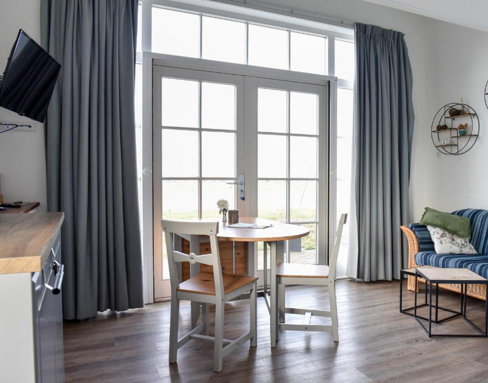 un salon avec une table et des chaises et une fenêtre dans l'établissement Pronkhuisje, à Oterleek
