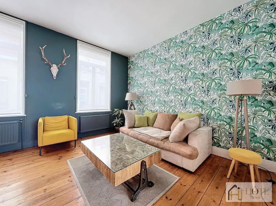 a living room with a couch and a table at Élégance Malouine - 500m Plage in Dunkerque
