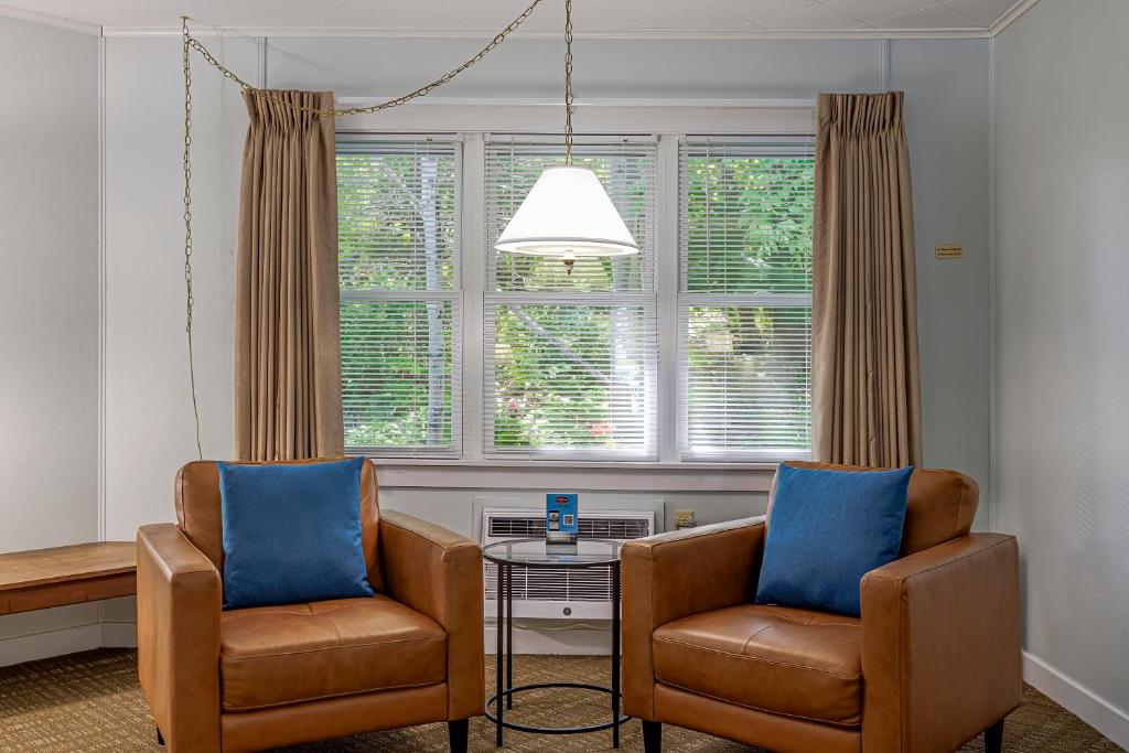two chairs and a table in a room with windows at Highbrook Motel in Bar Harbor