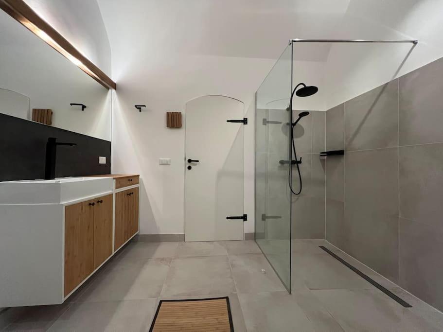 a bathroom with a glass shower and a sink at L'Arco Trieste studio living 1 in Trieste