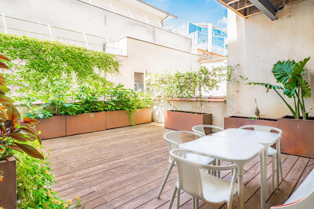 an outdoor patio with tables and chairs and plants at Magnifiques Appartements sur les Quais de Bordeaux in Bordeaux