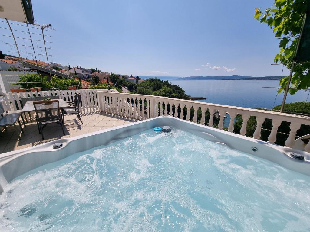 una vasca idromassaggio su un balcone con vista sull'acqua di NIKO LUX Apartment with Jacuzzi only 70m from the beach a Dramalj
