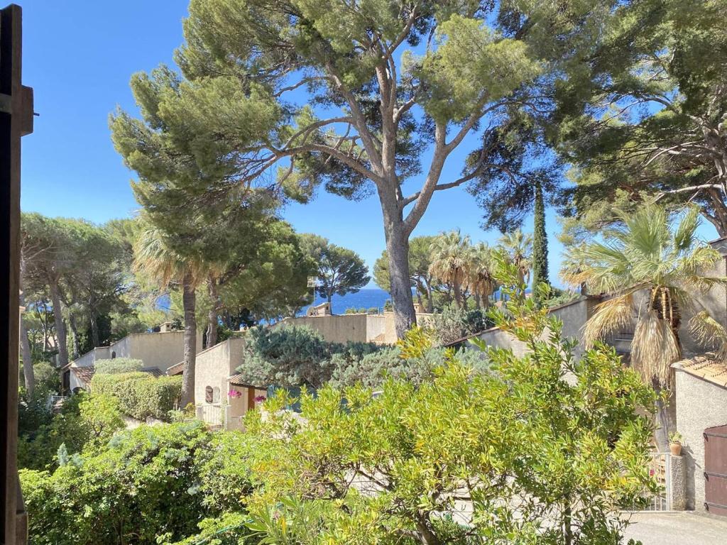 - une vue depuis le jardin d'une villa avec un arbre dans l'établissement Charmant T2 avec terrasse ombragée proche plage - 4 pers, parking privé - FR-1-770-5, à Saint-Cyr-sur-Mer