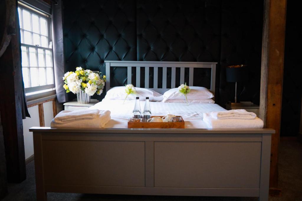 1 dormitorio con 1 cama con toallas en The Riverside Inn en Chelmsford