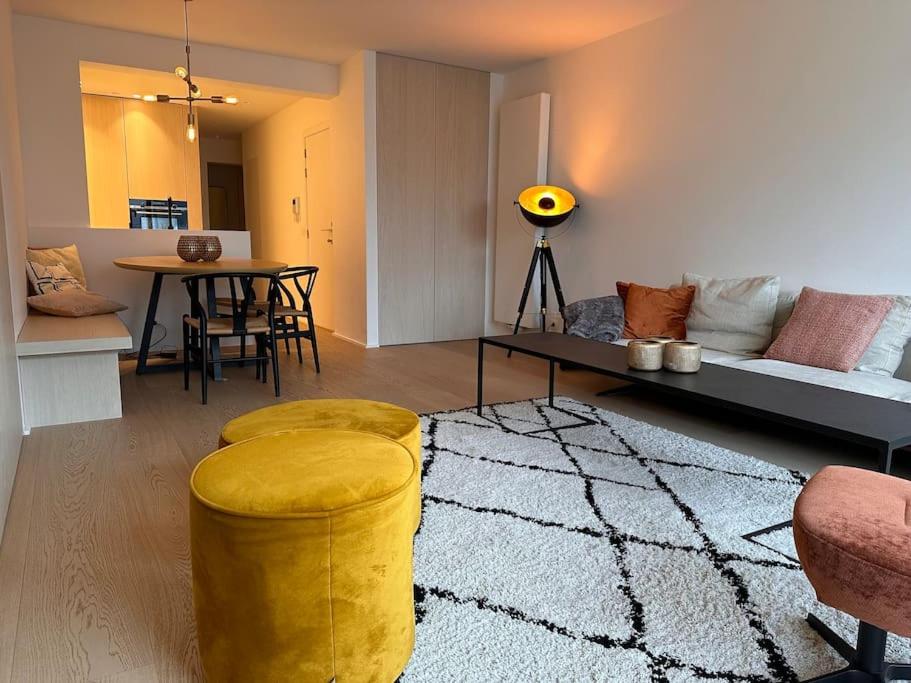 a living room with a couch and a table at Knokke Oasis Luxury Apartment in Centre in Knokke-Heist