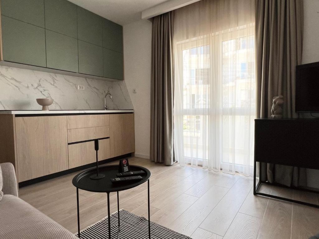 a living room with a table in front of a kitchen at Apartments Mrdak in Bar