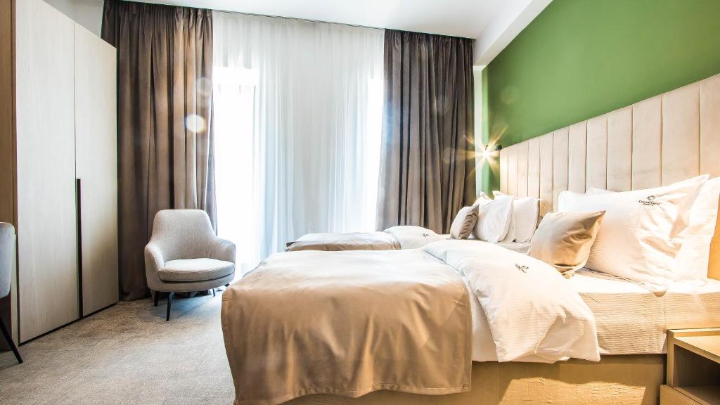 um quarto com uma cama grande e uma parede verde em Central Carol APARTHOTEL 2 em Bucareste