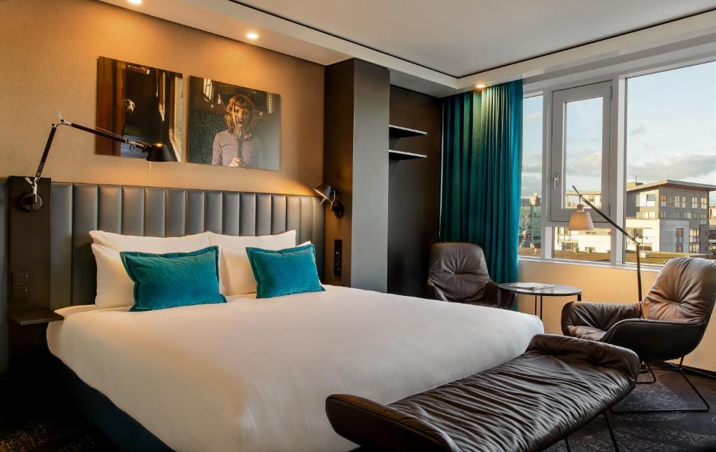 グラスゴーにあるMotel One Glasgowの大きなベッドと窓のあるホテルの部屋