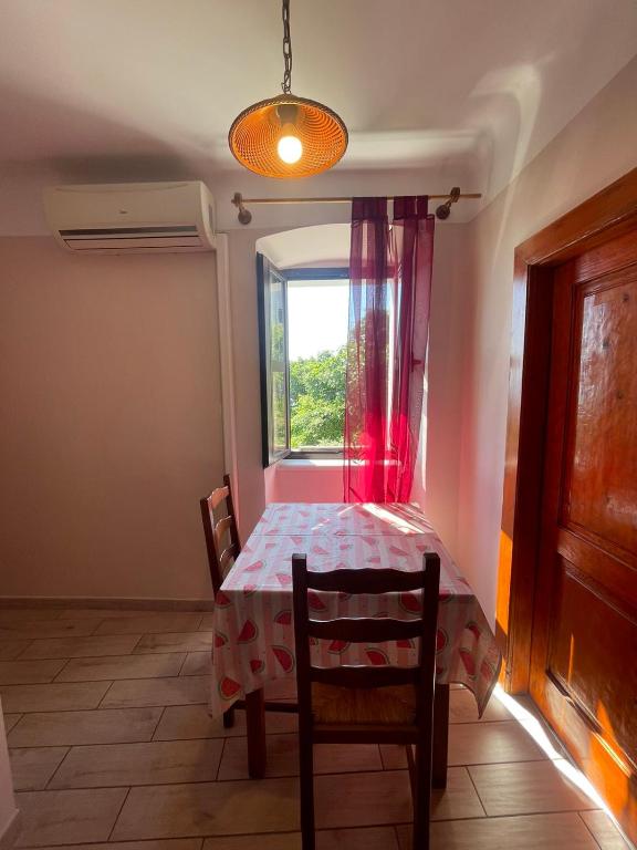 a dining room with a table and a window at Crveni apartman in Cres