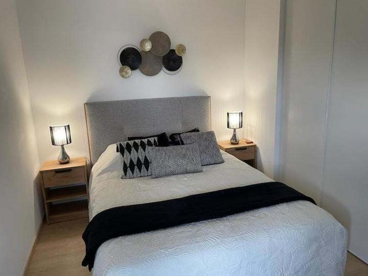 - une chambre avec un grand lit et 2 tables de chevet dans l'établissement le Natural, à Thonon-les-Bains