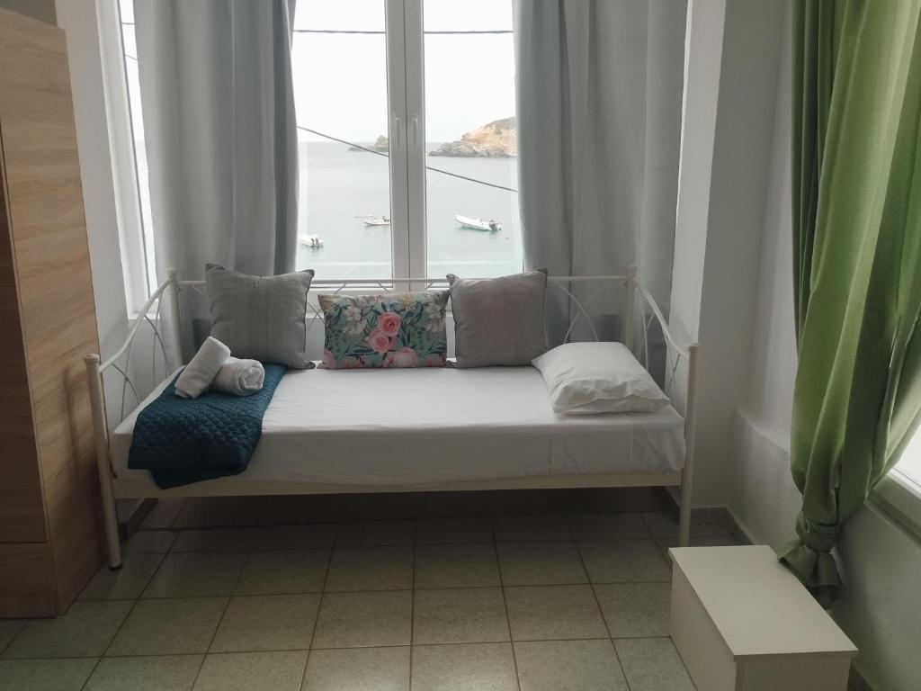 een bed in een kamer met een raam bij ANATOLI LYGARIA APTs on the beach in Lygaria