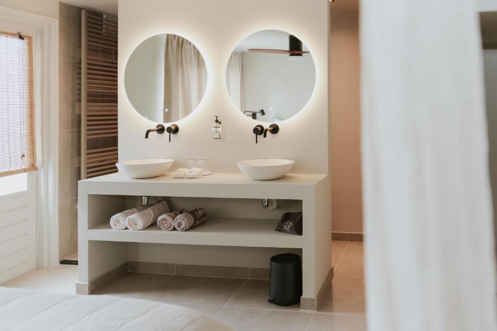 a bathroom with two sinks and two mirrors at Havenhuis Tilburg in Tilburg