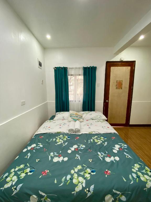 a bedroom with a bed with a blue comforter at Moalboal Panagsama beach TopBudz Hostel in Moalboal
