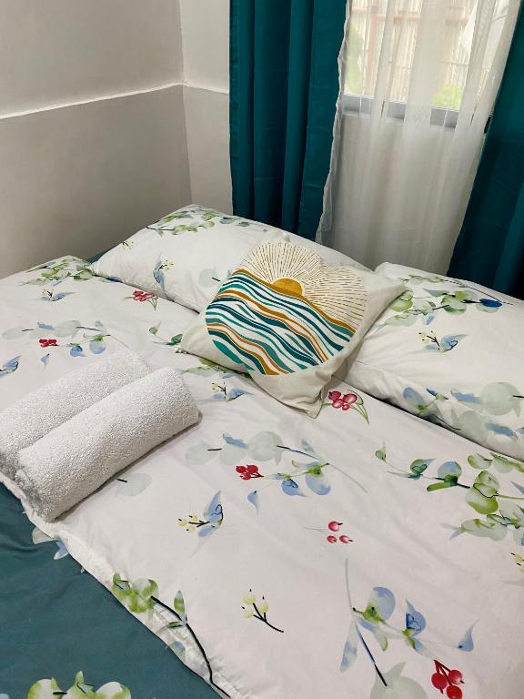 a bed with white sheets with flowers on it at Moalboal Panagsama beach TopBudz Hostel in Moalboal