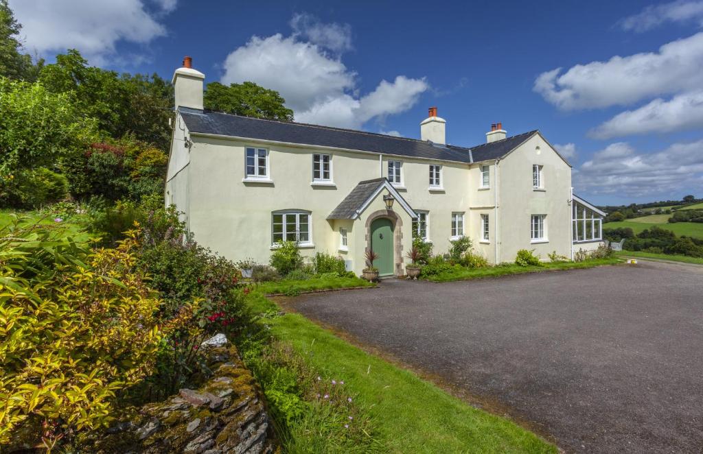 a large white house with a driveway at Stockham Farm, Dulverton in Dulverton