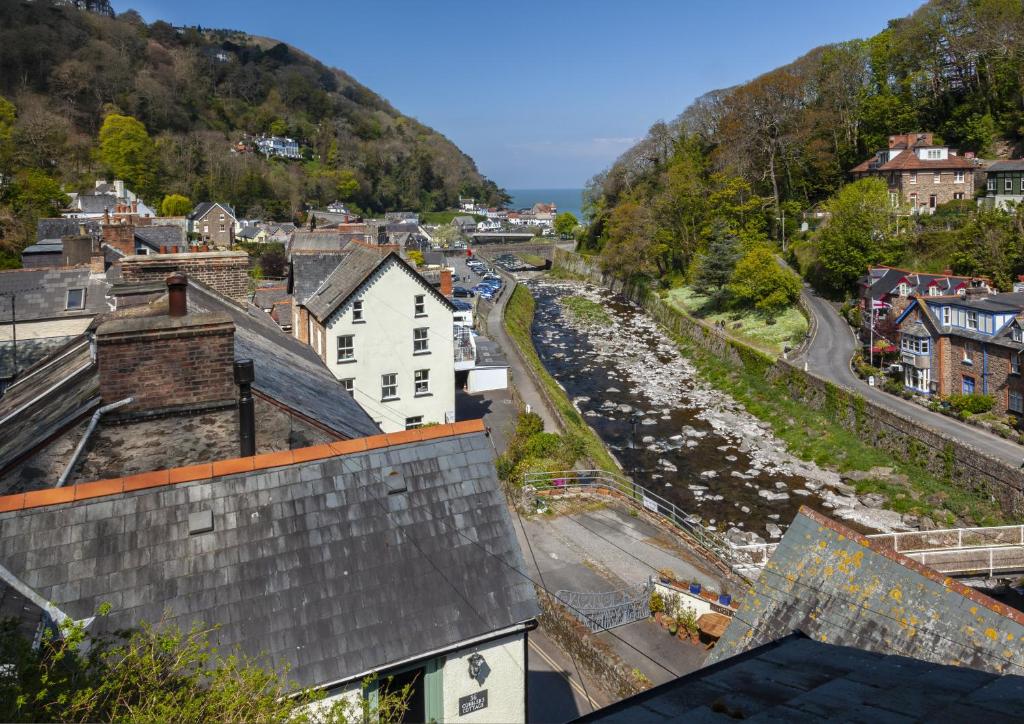 a view of a town with a river and buildings at Lorna Doone Cottage, Lynmouth in Lynmouth